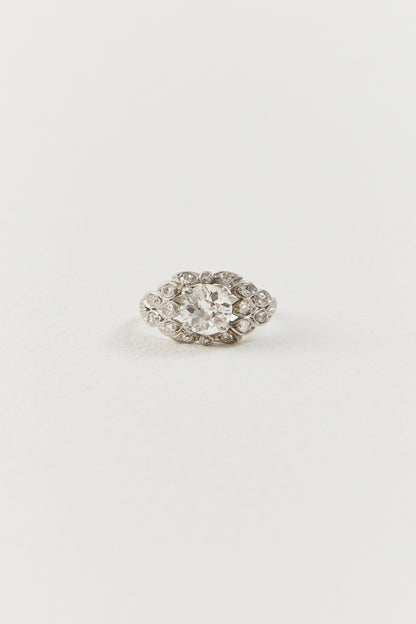  Showcasing a luminous 1.10 carat old European-cut diamond at its centre, the ring unfolds in an elongated navette-shaped composition, its softly curved borders tracing the outline of the centre diamond with considered grace. Sixteen single-cut diamonds are arranged in a flowing, organic framework around the centre stone, each one bezel-set and carefully placed to follow the natural r