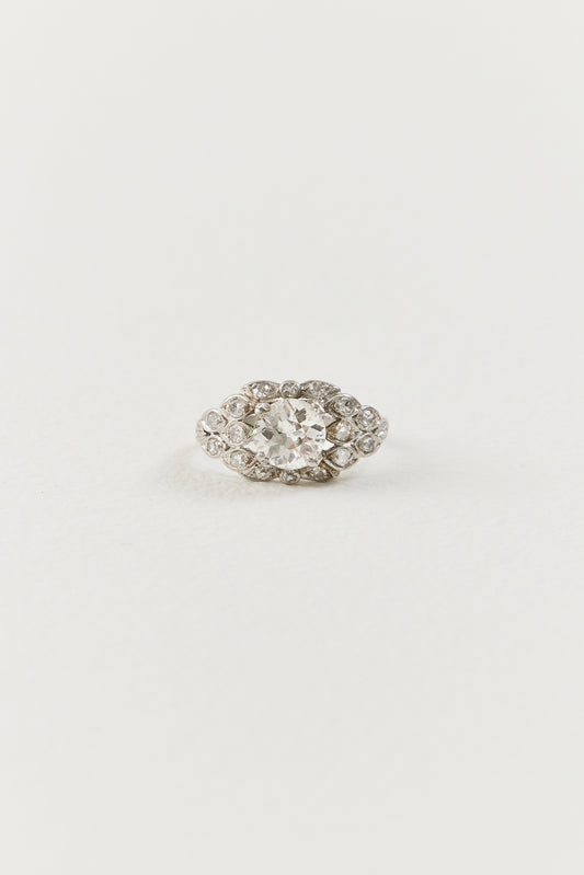  Showcasing a luminous 1.10 carat old European-cut diamond at its centre, the ring unfolds in an elongated navette-shaped composition, its softly curved borders tracing the outline of the centre diamond with considered grace. Sixteen single-cut diamonds are arranged in a flowing, organic framework around the centre stone, each one bezel-set and carefully placed to follow the natural r