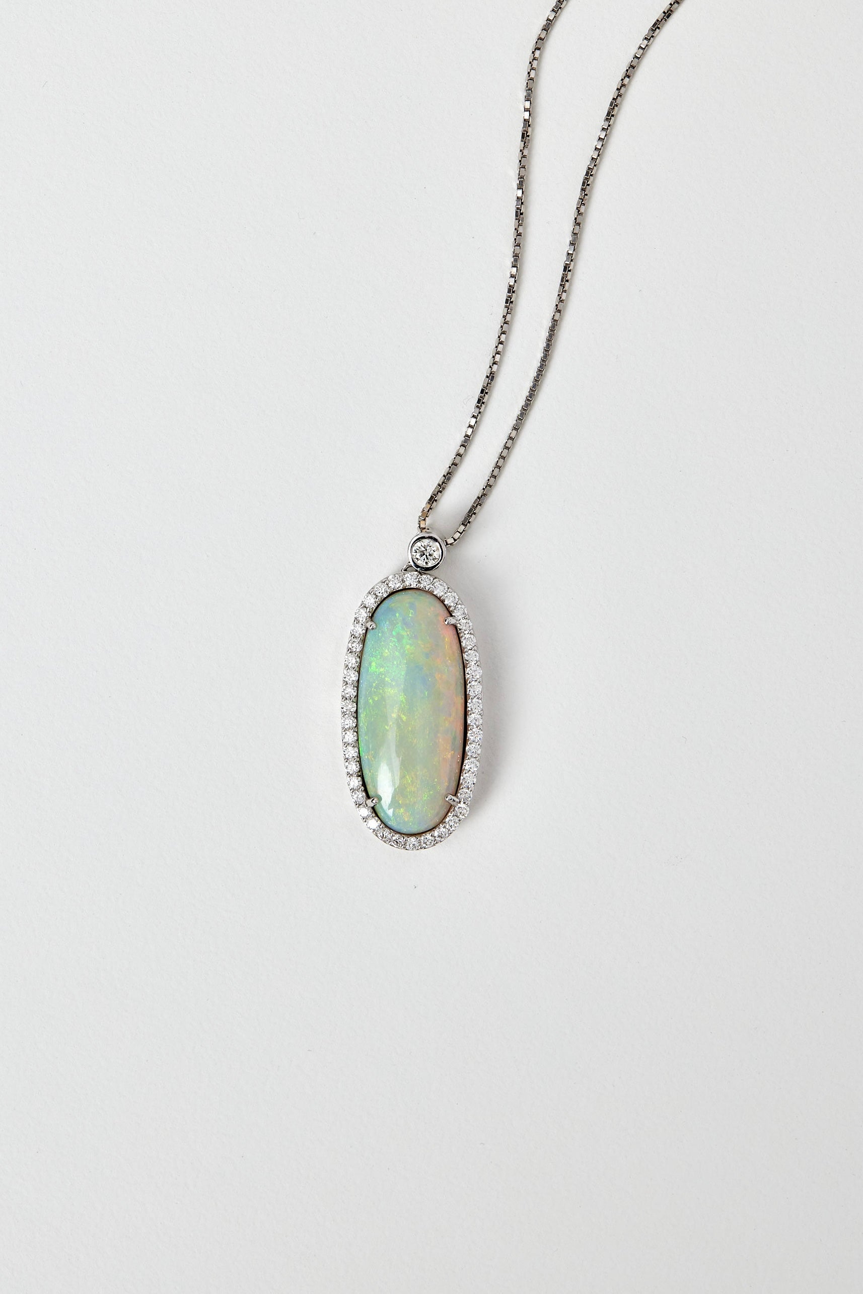 solid opal pendant with halo diamonds in 18ct white gold